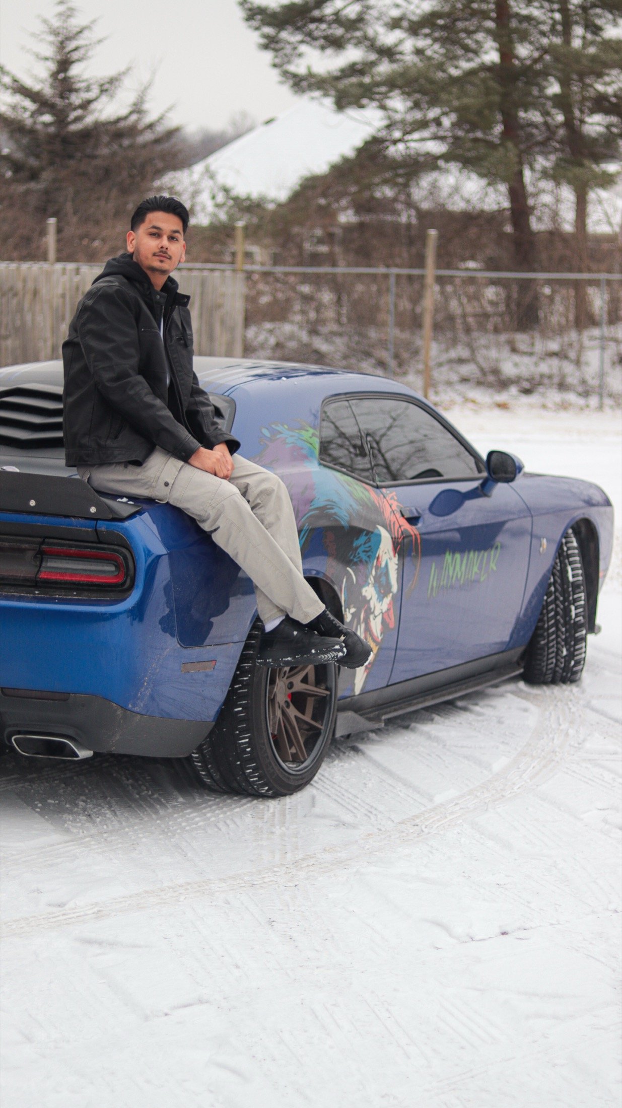 Sanchit Gogna seated beside a blue car